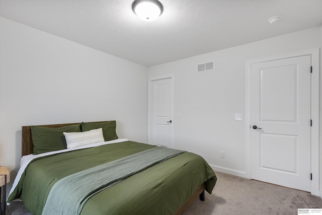 bedroom with a textured ceiling and carpet floors