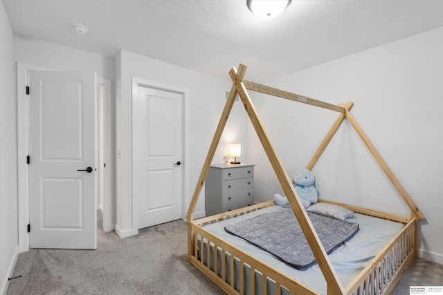 bedroom with carpet floors and a textured ceiling