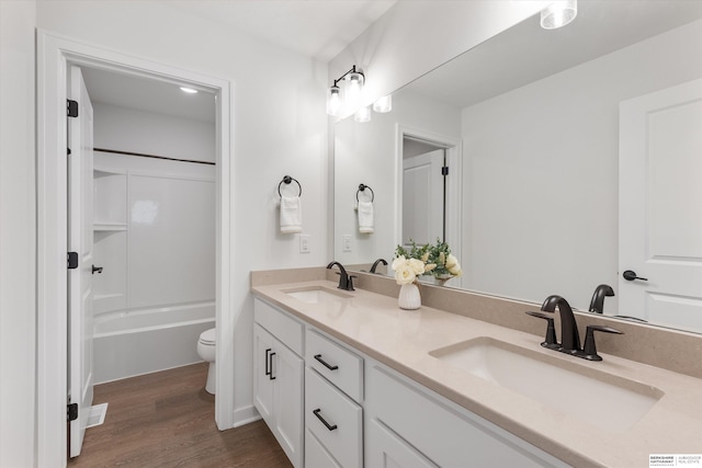 full bathroom featuring toilet, washtub / shower combination, vanity, and wood-type flooring