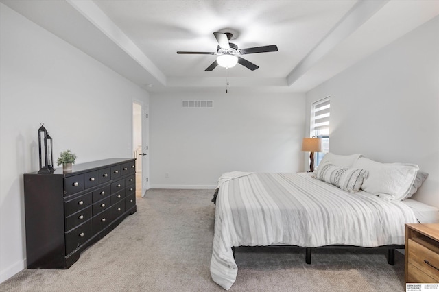 bedroom featuring light colored carpet, ceiling fan, and a raised ceiling