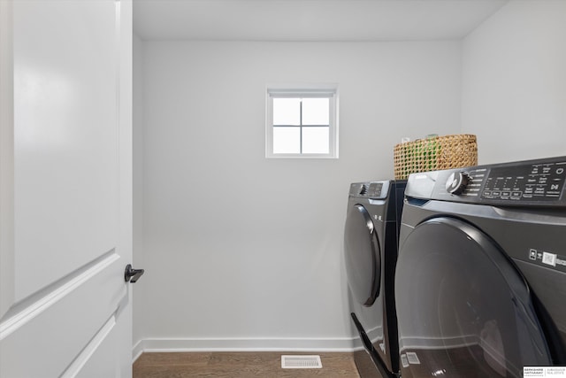 laundry room with dark wood-type flooring and washer and dryer