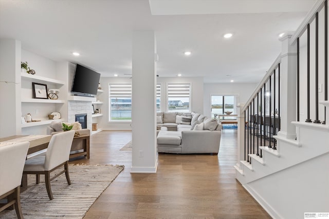 living room with built in features and hardwood / wood-style flooring