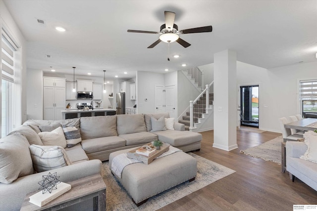 living room with dark wood-type flooring and ceiling fan