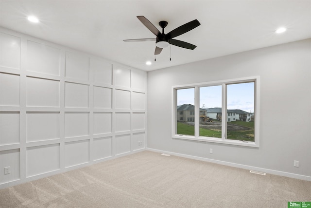 carpeted spare room with ceiling fan