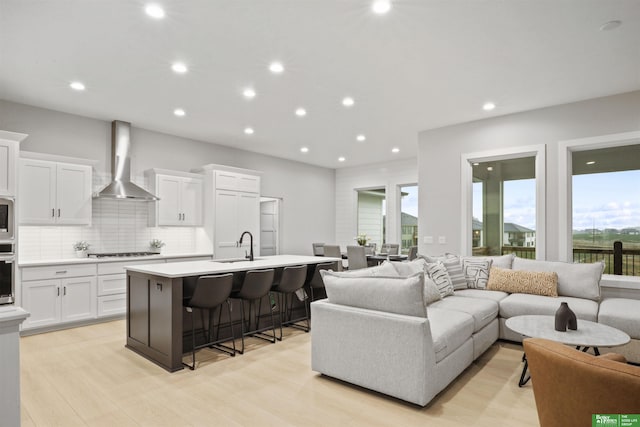 living room with light hardwood / wood-style floors and sink