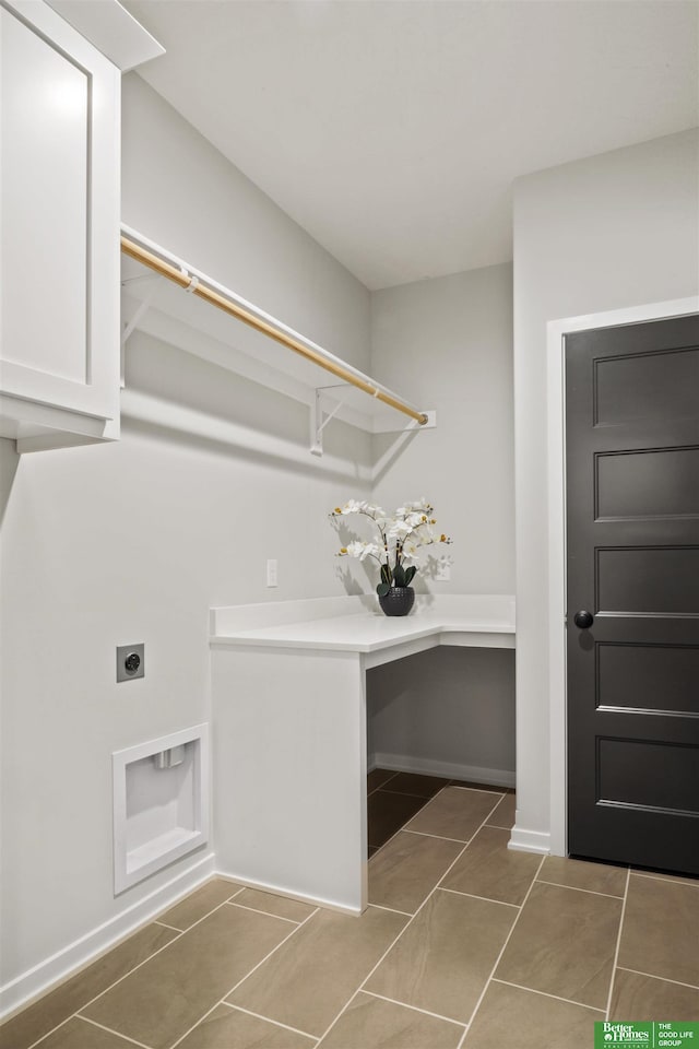 clothes washing area with hookup for an electric dryer, tile patterned flooring, and cabinets