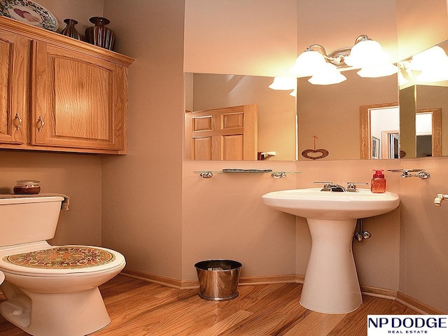 bathroom with hardwood / wood-style flooring and toilet