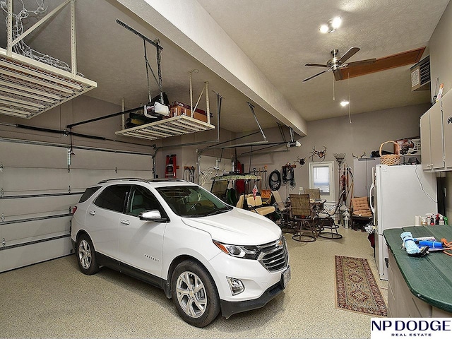 garage featuring a garage door opener, ceiling fan, and white fridge