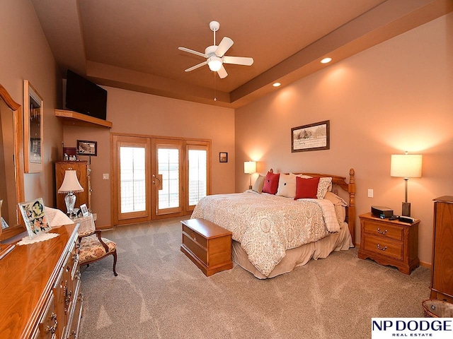 carpeted bedroom featuring ceiling fan, french doors, and a tray ceiling