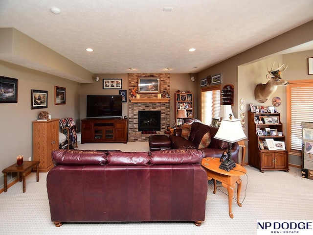 living room featuring light colored carpet, a textured ceiling, and a stone fireplace