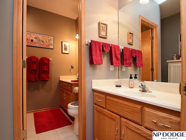 bathroom featuring tile patterned flooring, vanity, and toilet