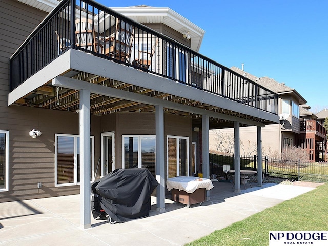 back of house with a deck and a patio