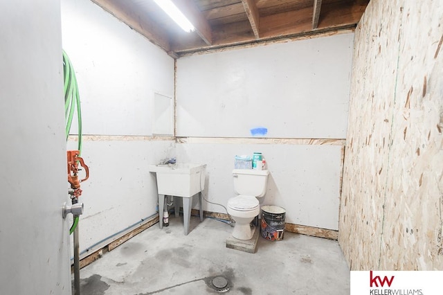 bathroom with concrete flooring and toilet