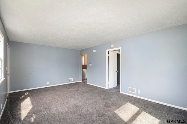 carpeted spare room featuring a textured ceiling