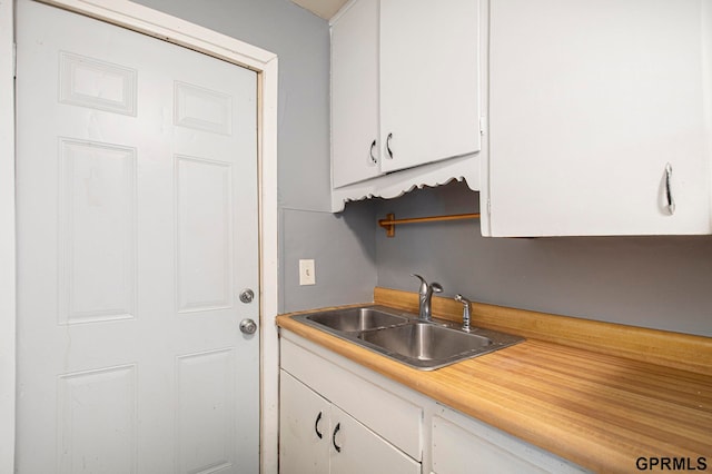 kitchen featuring white cabinetry and sink