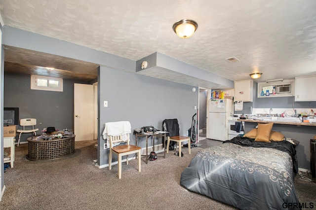 carpeted bedroom featuring a textured ceiling, sink, and white refrigerator