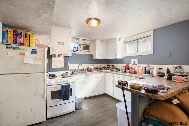 kitchen with kitchen peninsula, white appliances, dark hardwood / wood-style floors, and white cabinets