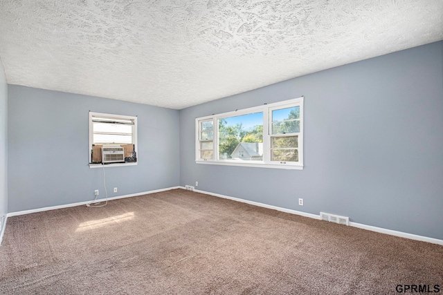 unfurnished room featuring carpet, a textured ceiling, and cooling unit