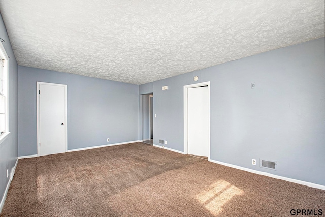 carpeted spare room with a textured ceiling