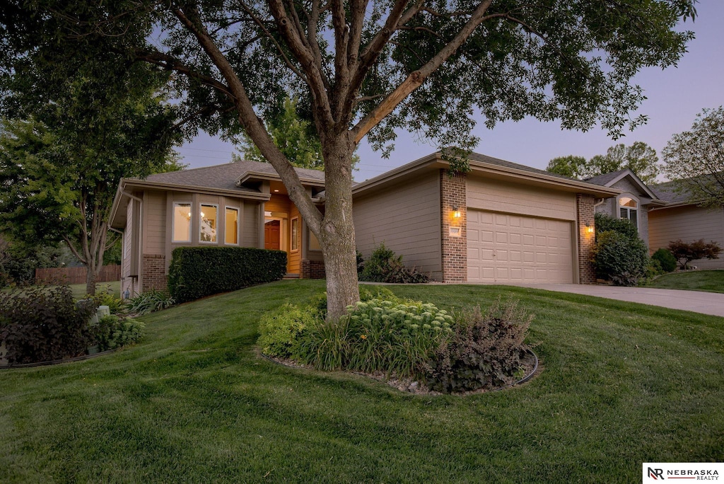 view of front of home with a garage and a lawn