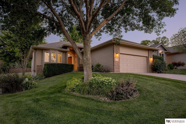 view of front of home with a garage and a lawn