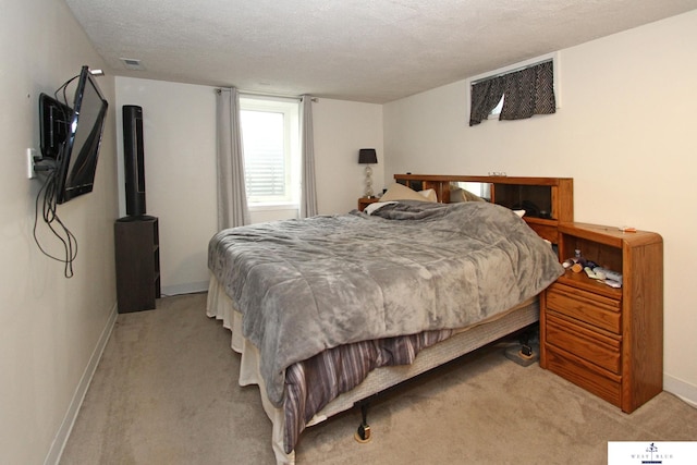 bedroom featuring a textured ceiling and light carpet