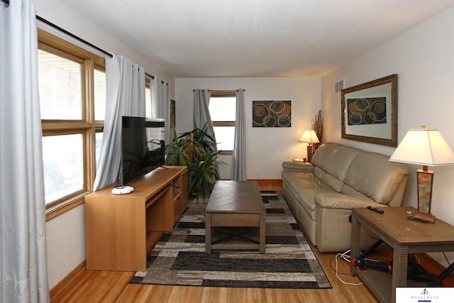 living room featuring a wealth of natural light and light hardwood / wood-style flooring