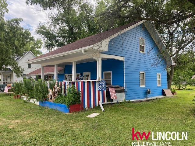 back of property with a porch and a yard