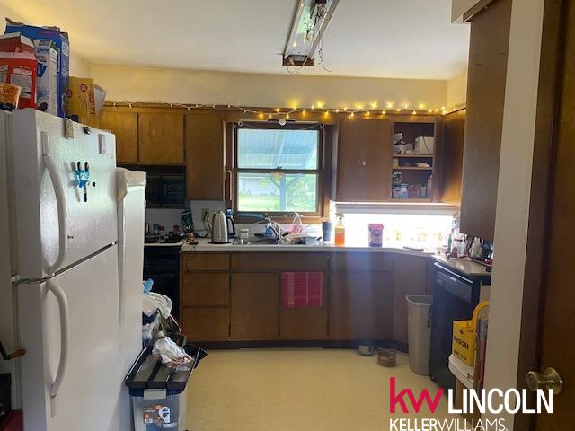 kitchen featuring dishwasher, sink, and white fridge