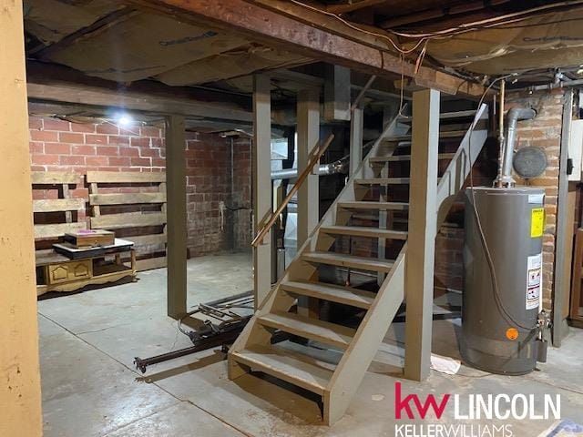 basement with gas water heater and brick wall