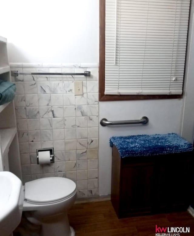 bathroom with hardwood / wood-style flooring, tile walls, and toilet