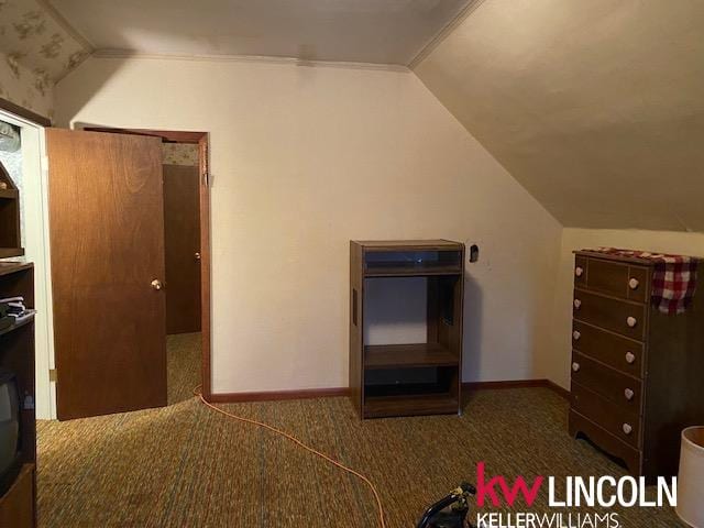 unfurnished bedroom featuring dark colored carpet and vaulted ceiling