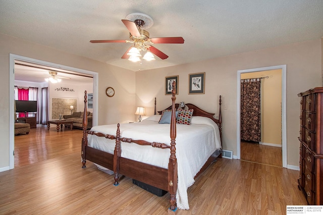 bedroom featuring ceiling fan, light hardwood / wood-style floors, and a textured ceiling