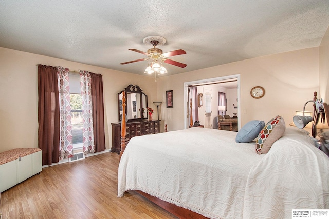 bedroom featuring wood-type flooring, a textured ceiling, and ceiling fan