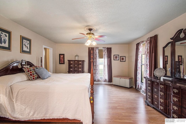 bedroom featuring radiator, ceiling fan, hardwood / wood-style floors, and a textured ceiling