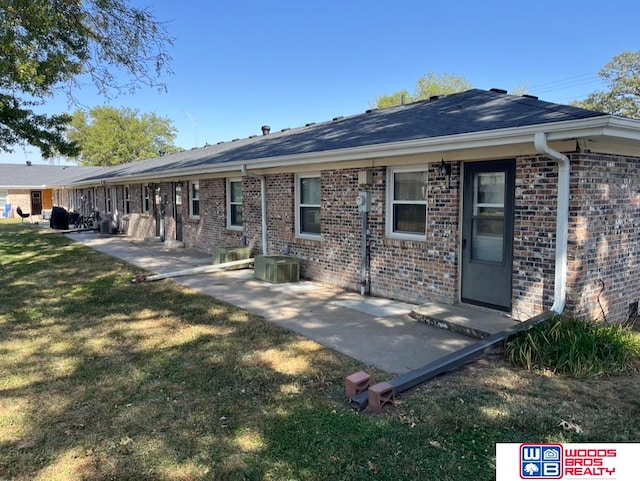 rear view of house featuring a patio and a yard