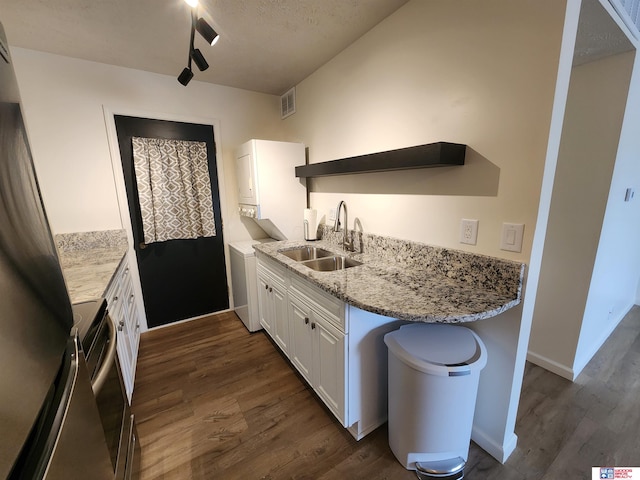 kitchen featuring dark hardwood / wood-style floors, stainless steel electric range oven, sink, white cabinets, and stacked washer / drying machine