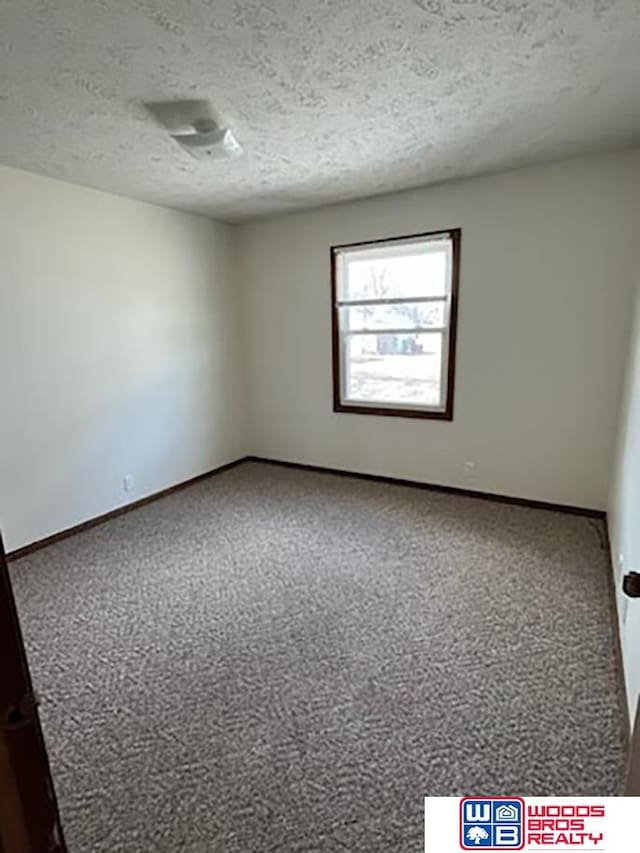 unfurnished room featuring a textured ceiling and carpet floors