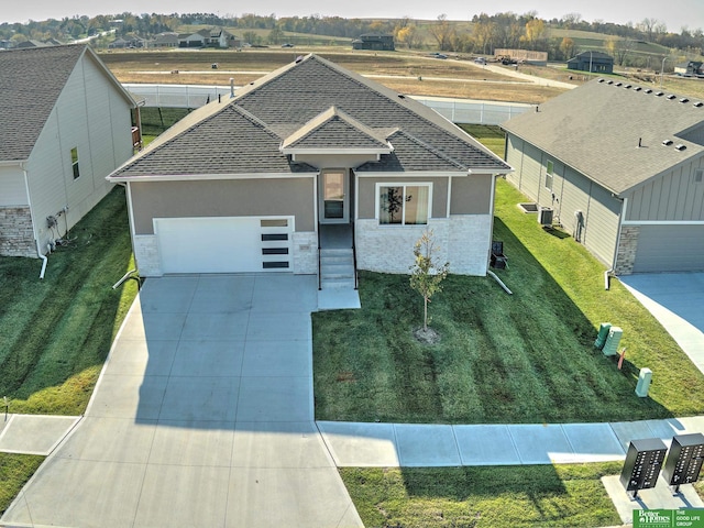 view of front of home featuring a garage, cooling unit, and a front yard