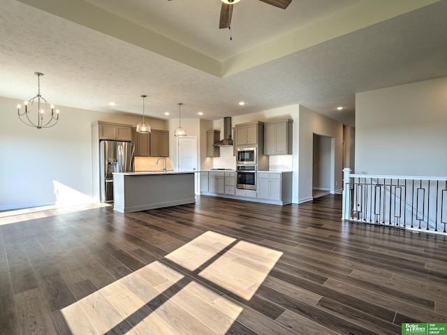 unfurnished living room with ceiling fan with notable chandelier, a textured ceiling, sink, and dark hardwood / wood-style flooring