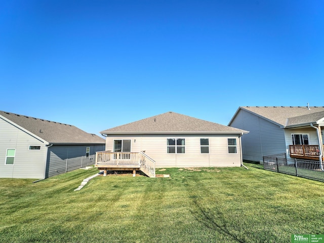 back of house with a deck and a yard