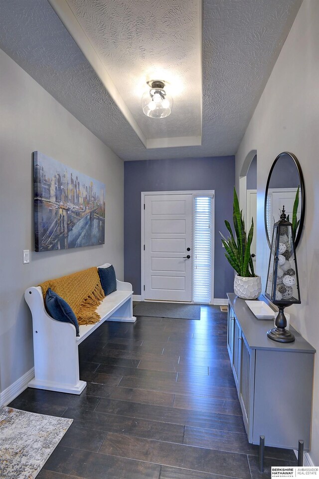 foyer entrance featuring a textured ceiling and dark hardwood / wood-style flooring