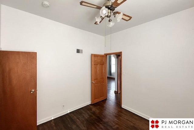 empty room with dark wood-type flooring and ceiling fan