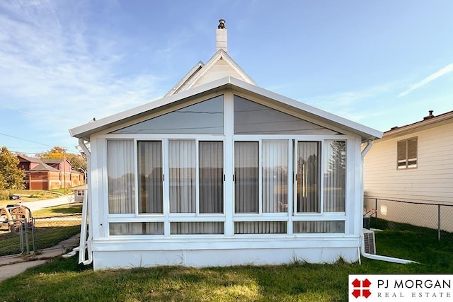 back of property with a sunroom and a yard