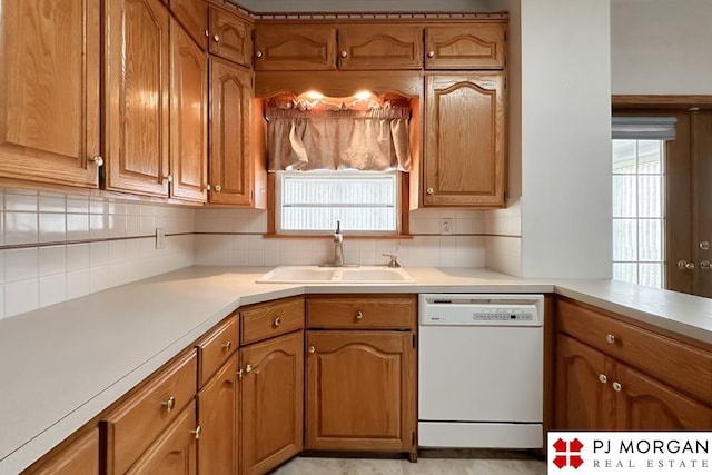 kitchen with white dishwasher, sink, and tasteful backsplash