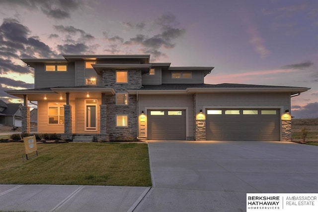 prairie-style home featuring a garage and a yard