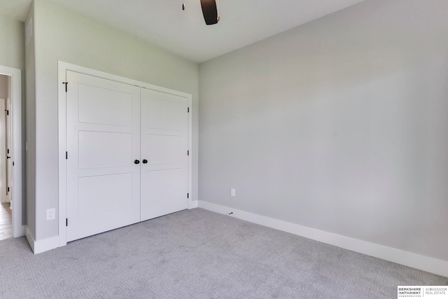 unfurnished bedroom with ceiling fan, a closet, and light colored carpet