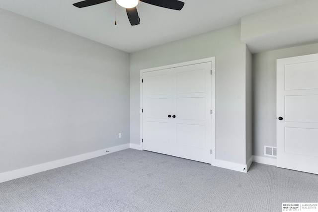 unfurnished bedroom featuring a closet, light colored carpet, and ceiling fan