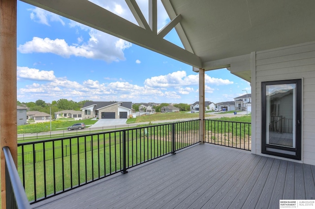 wooden terrace with a lawn and a garage