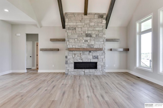 unfurnished living room with a fireplace, a wealth of natural light, and light hardwood / wood-style floors